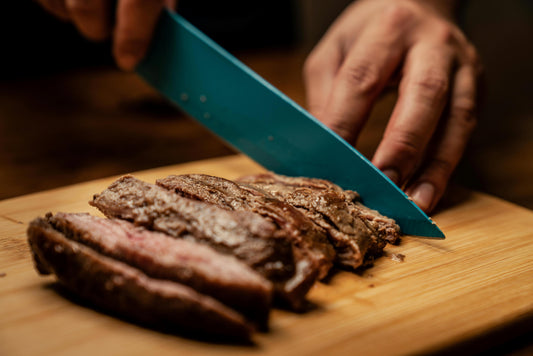 Someone Using a Cutting Board to Slice Meat